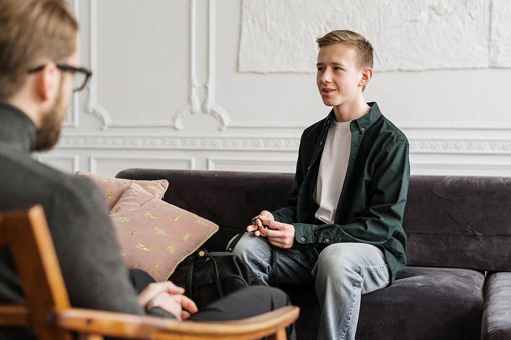 young man speaking to clinician
